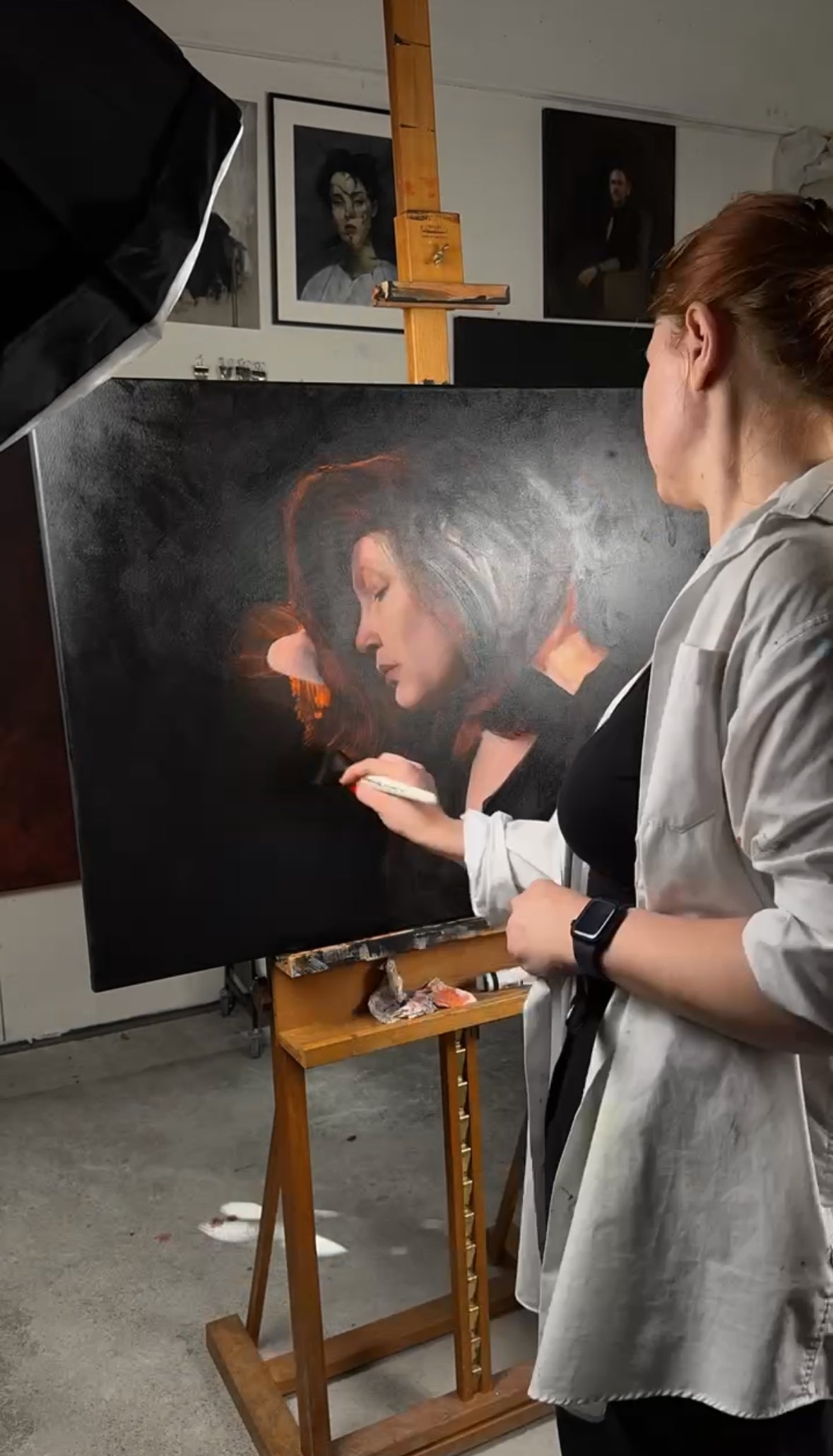 Die Künstlerin beim Malen an ihrem Selbstporträt, professionelle Gemälde von Tatjana Kpunkt, Kunst aus Biberach an der Riß, Porträtmalerei im süddeutschen Raum, Kunst aus Baden-Württemberg, Acrylmalerei. Ölmalerei auf Leinwand, klassische Kunst, moderne Kunst, schwarzer Hintergrund, exklusive Kunst, upcoming artist, Auftragskunst, Realismus, figurative Kunst